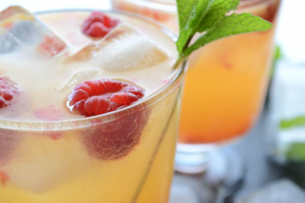 A delicious sweet tart Raspberry Mango Paloma cocktail, made with Trader Joes Mango Lemonade, fresh summer raspberries & Patron's Mango Citronage. | onesimplefeast.com