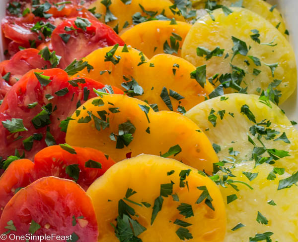 Summer marinated heirloom tomato salad, zesty and garlicy goodness seasoned tomatoes perfect in your next sandwich or grilled cheese, perfect with fresh mozzarella cheese on a platter at your next BBQ!